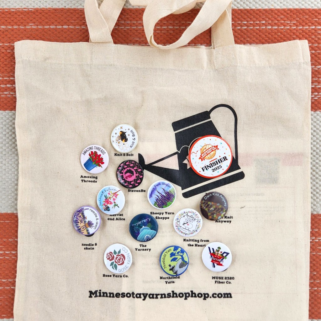 Canvas bag with pins from local yarns stores in the Twin Cities area.